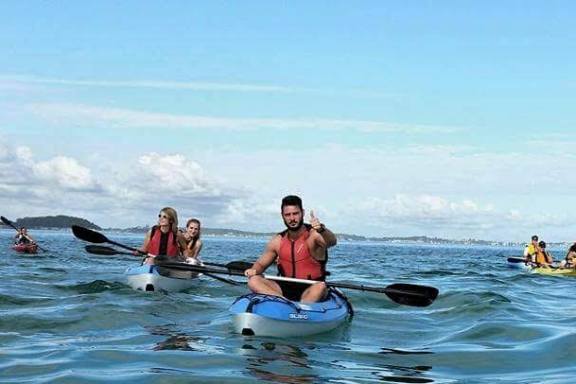 a group of people rowing a boat in the water